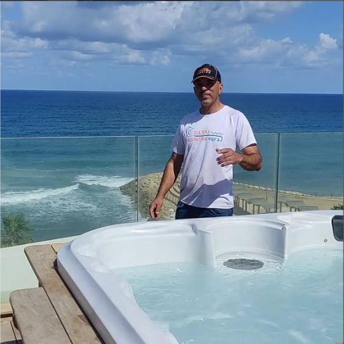 טכנאי דני ג'קוזי ליד ג'קוזי פעיל עם נוף ים, שירות תיקון ושדרוג.